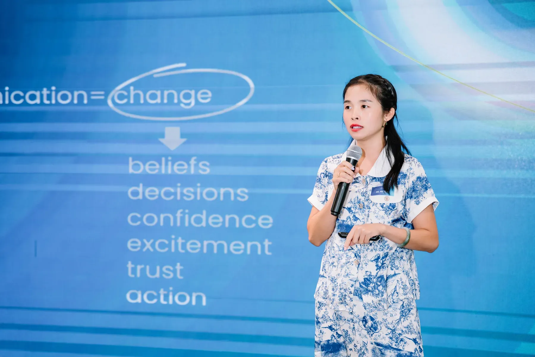 Ha Tran speaking on stage about how communication creates change